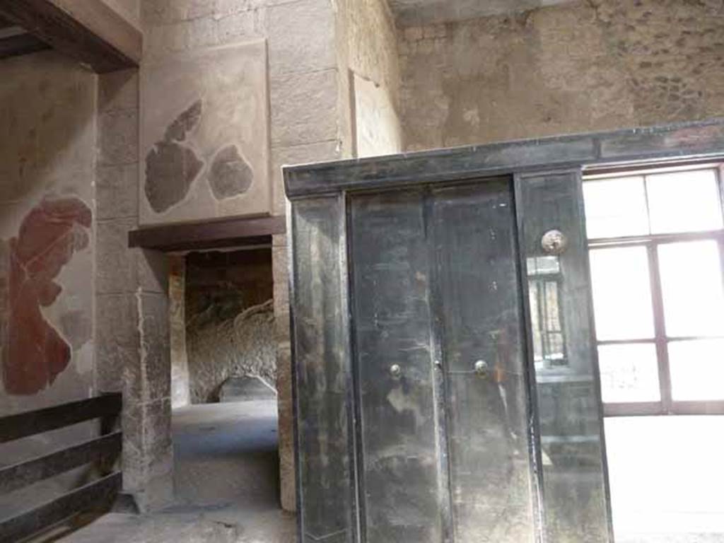 III.11 Herculaneum. May 2010. Doorway to room 8, in south-west corner of atrium, with wooden screen/partition, on right.